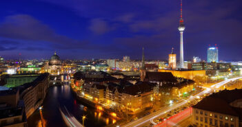 Berliner Immobilien sind nach wie vor heiß begehrt – Ioannis Moraitis Beleuchtete Straßen und Wohnungen in Berlin bei Dämmerung.