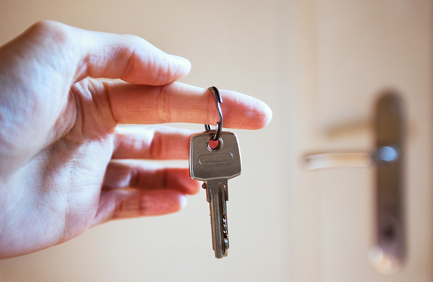 Mann hält einen Wohnungsschlüssel in der Hand.